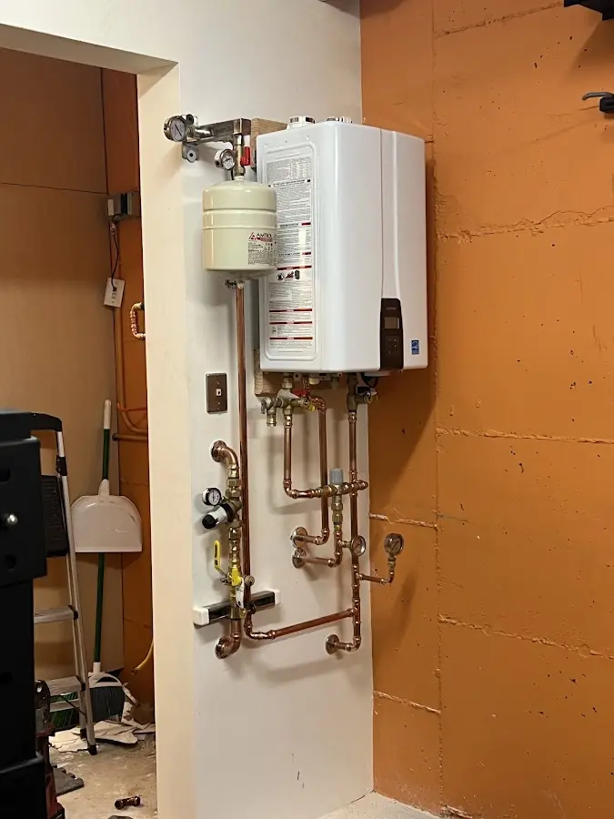 Plumbing technician inspecting water heater connections in Pequea